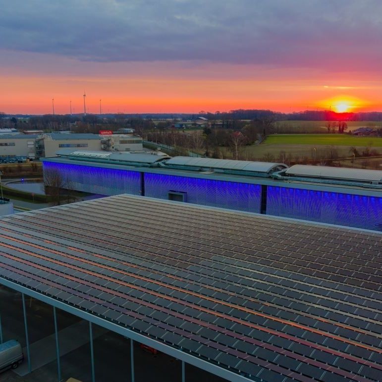 Photovoltaikanlage auf einem Dach mit einem Sonnenuntergang im Hintergrund