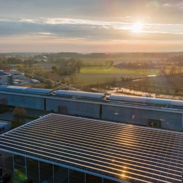 Photovoltaikanlage auf einem Dach mit einem Sonnenuntergang im Hintergrund